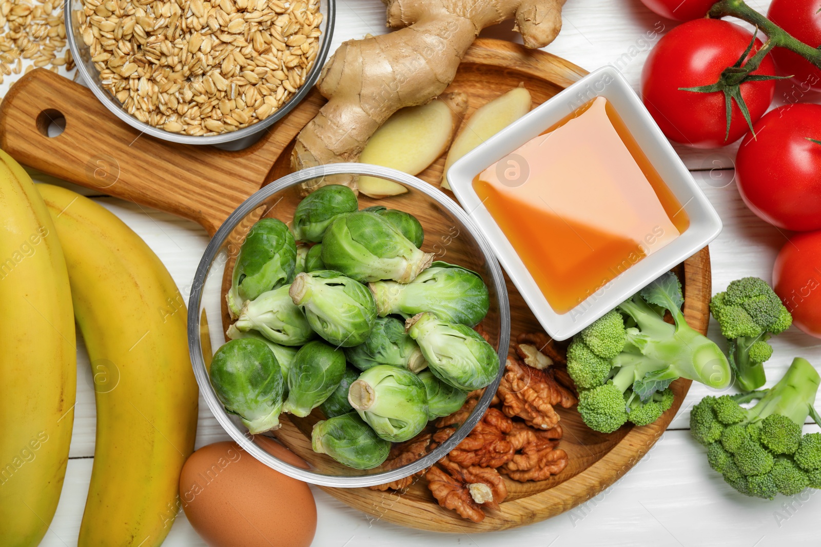 Photo of Different fresh products rich in melatonin on white wooden table, flat lay