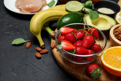 Photo of Different fresh products rich in dopamine on grey textured table. Space for text