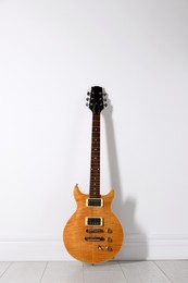 Photo of One modern electric guitar near white wall