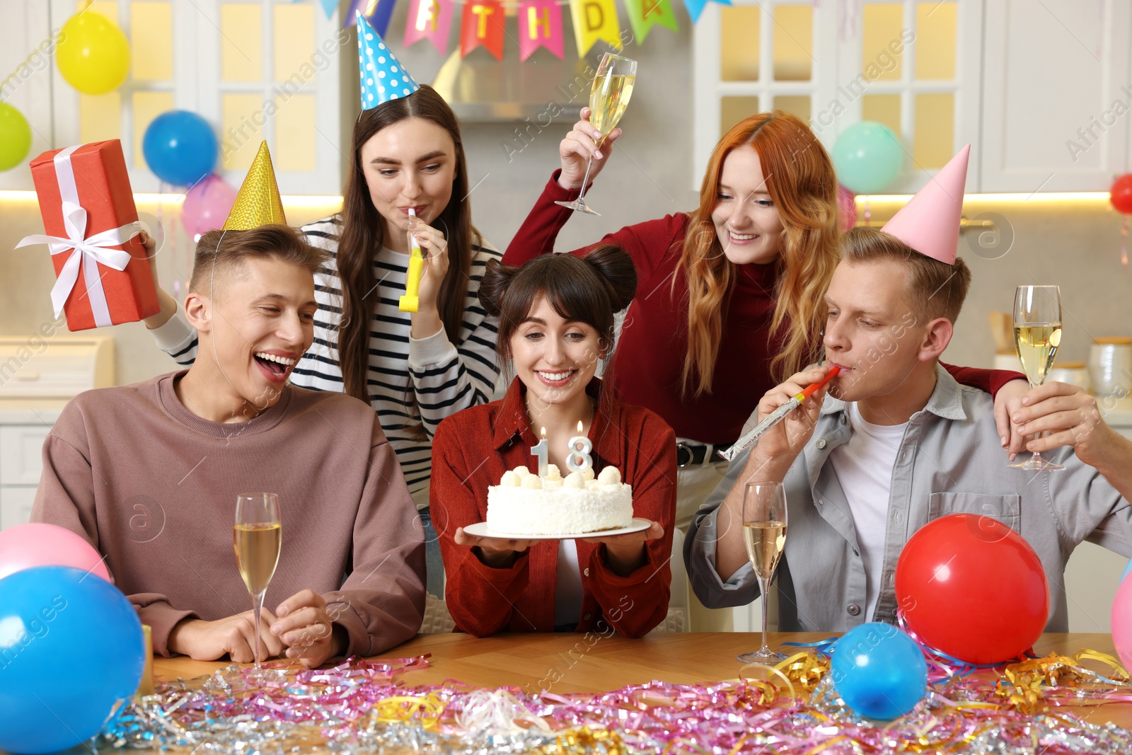 Photo of 18th birthday. Group of friends with tasty cake having coming of age party at home