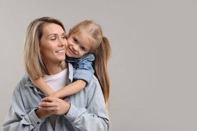 Photo of Cute little girl with her mom on gray background, space for text. Happy Mother's Day