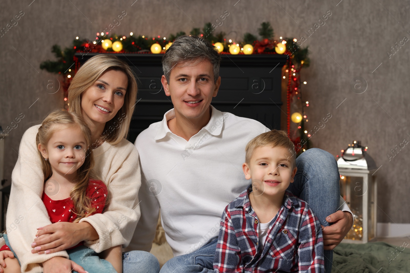 Photo of Beautiful family near fireplace at home. Christmas season