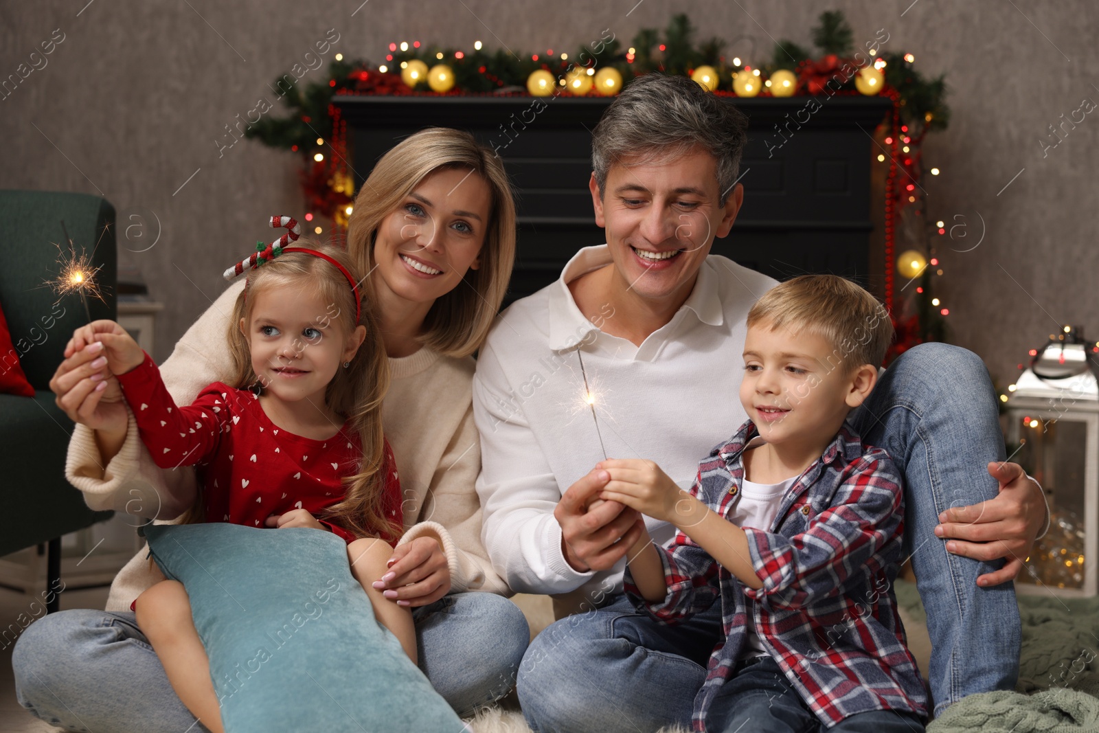 Photo of Lovely family with Christmas sparklers at home