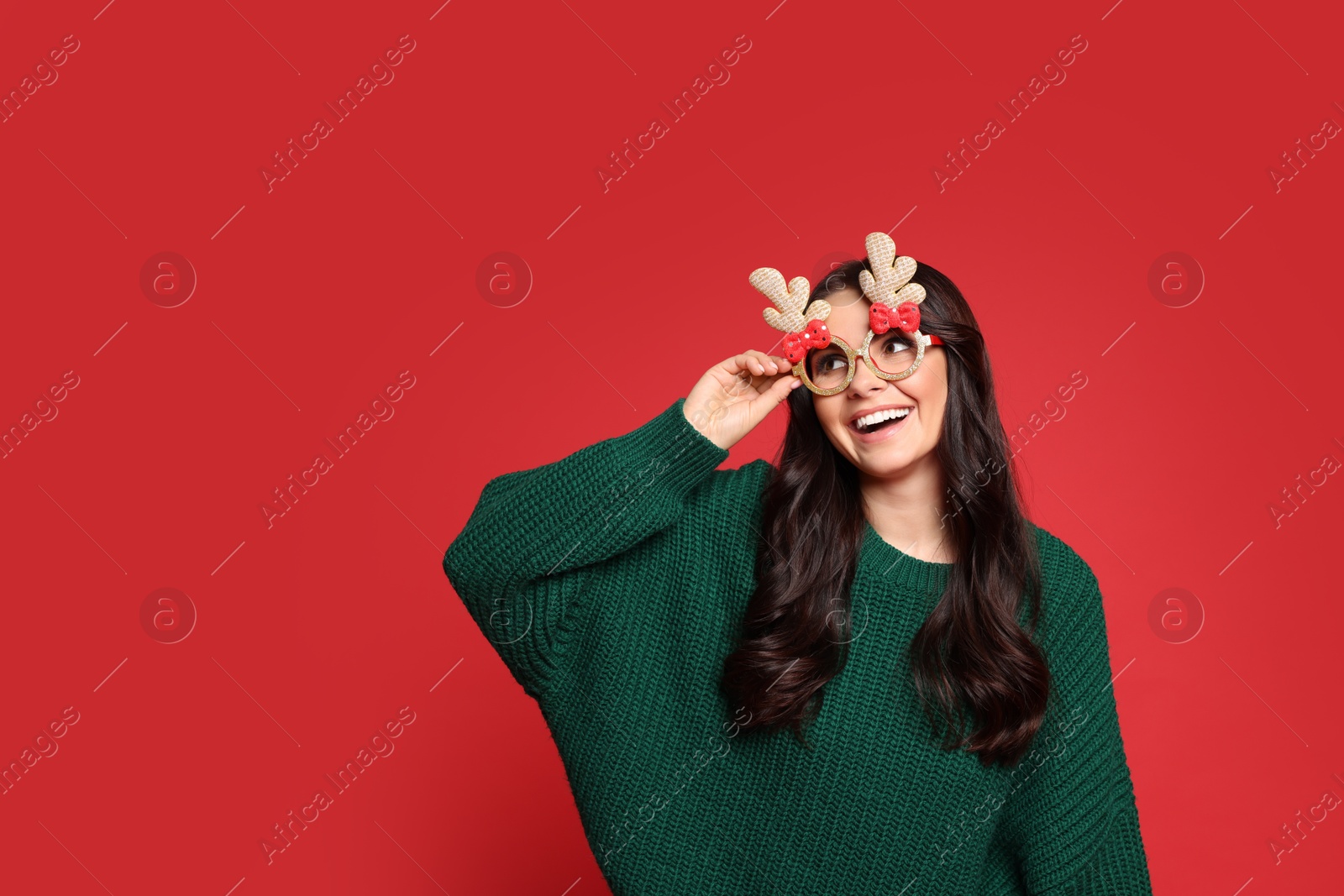 Photo of Happy woman with party glasses on red background. Christmas celebration, space for text