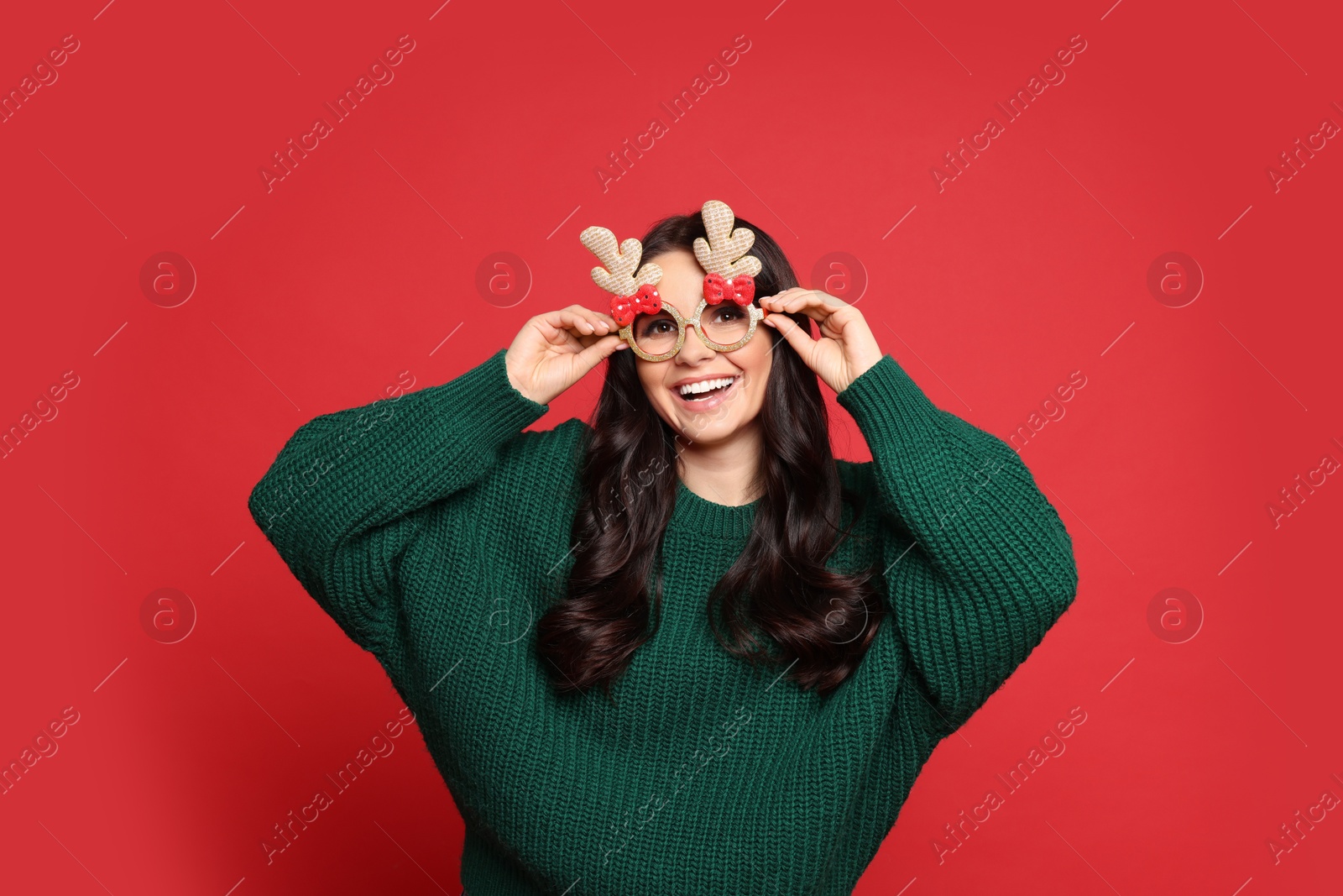 Photo of Happy woman with party glasses on red background. Christmas celebration