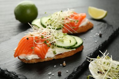 Photo of Delicious bruschette with salmon, cream cheese and cucumber on grey table, closeup