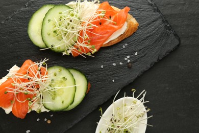 Photo of Delicious bruschette with salmon, cream cheese and cucumber on grey table, flat lay