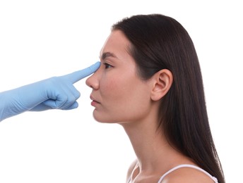 Photo of Doctor checking patient's nose before plastic surgery operation on white background, closeup