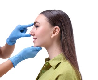 Photo of Doctor checking patient's nose before plastic surgery operation on white background, closeup