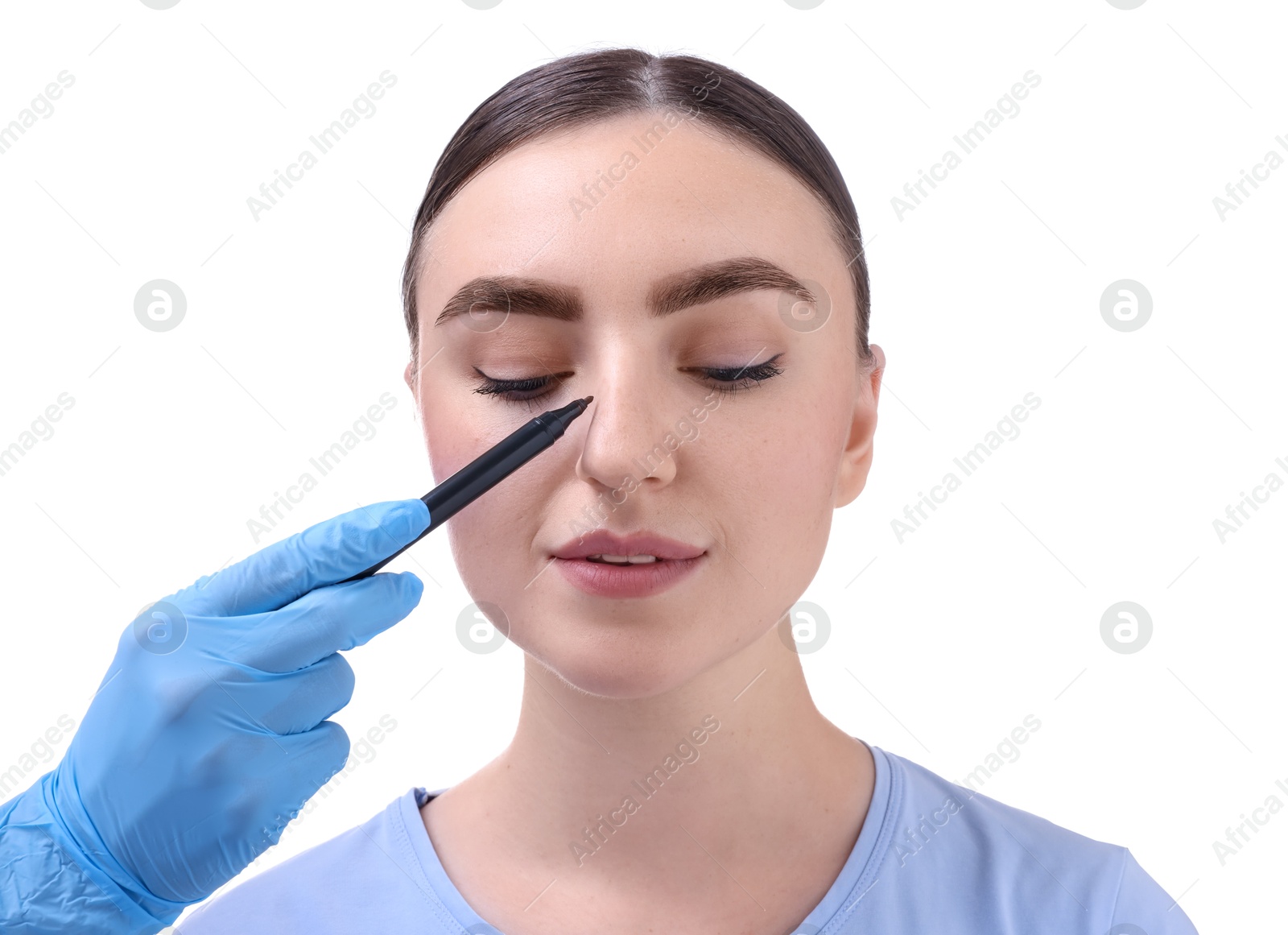 Photo of Doctor drawing marks on patient's nose for plastic surgery operation against white background, closeup