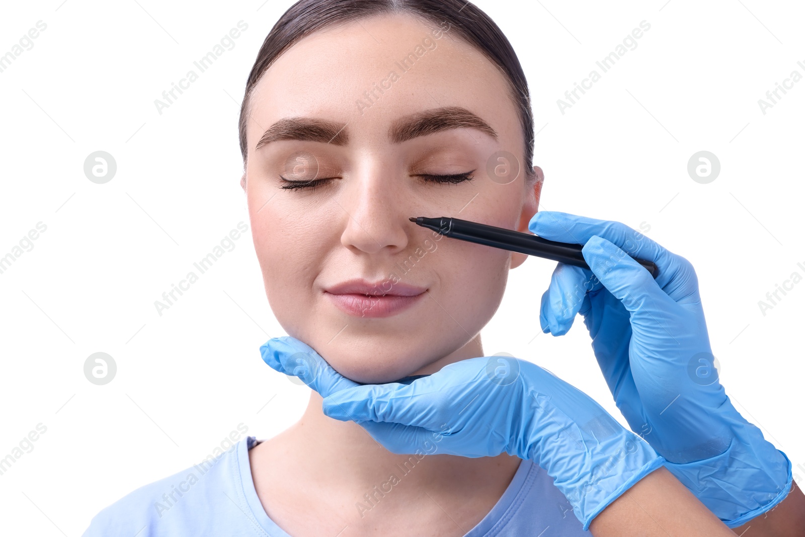 Photo of Doctor drawing marks on patient's nose for plastic surgery operation against white background, closeup