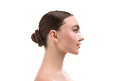 Photo of Woman with medical bandage on her nose after plastic surgery operation against white background