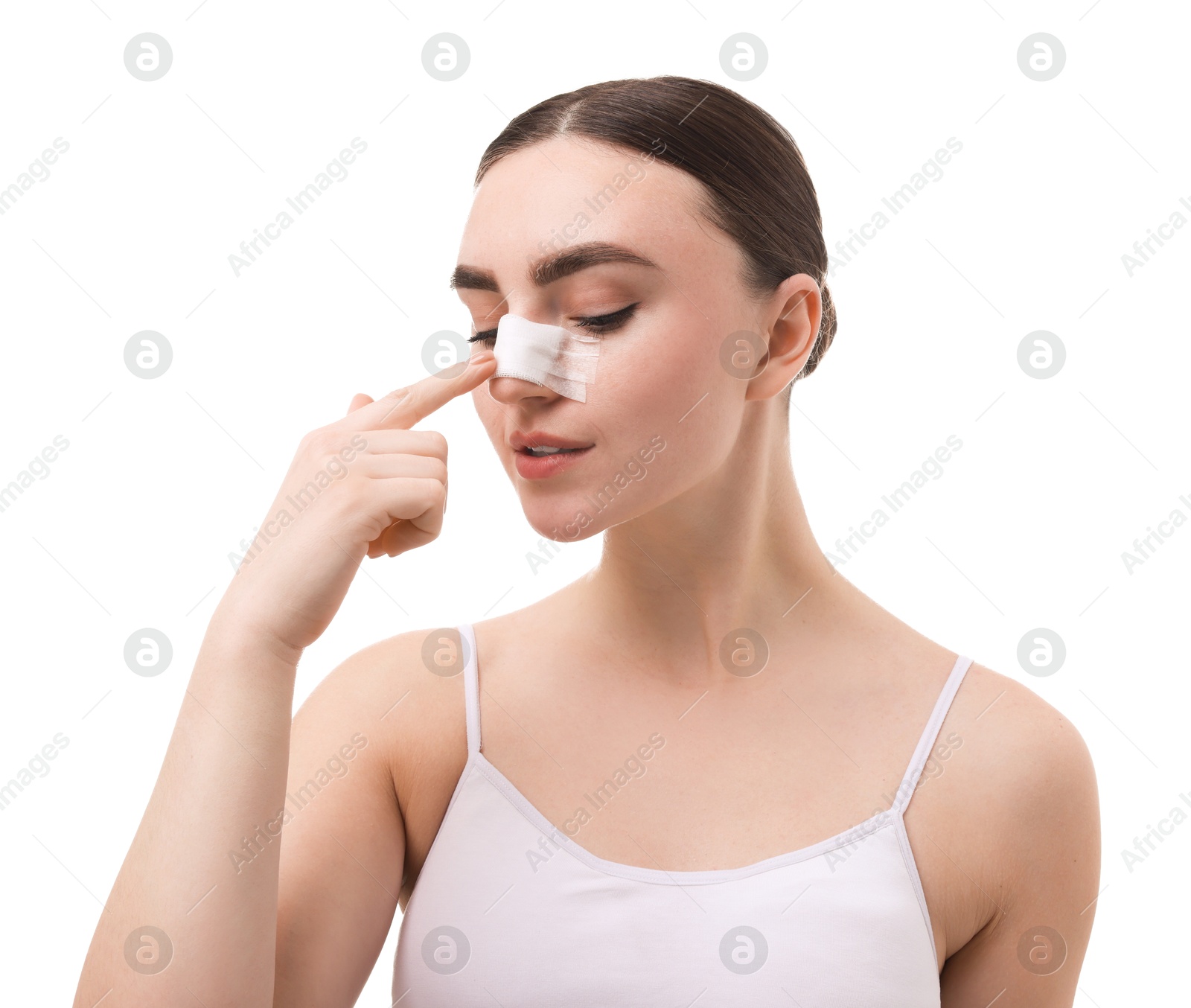 Photo of Woman with medical bandage on her nose after plastic surgery operation against white background