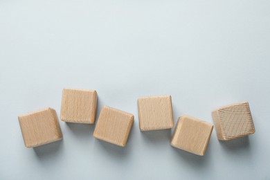 Photo of Many wooden cubes on grey background, flat lay. Space for text