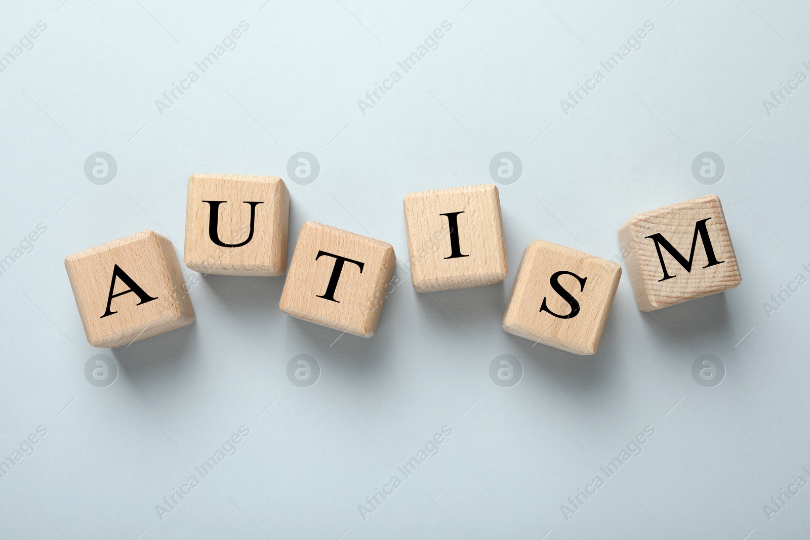 Photo of Word Autism made with wooden cubes on grey background, flat lay