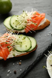 Photo of Delicious bruschette with salmon, cream cheese and cucumber on grey table, closeup