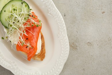 Photo of Delicious bruschetta with salmon, cream cheese and cucumber on light table, top view. Space for text