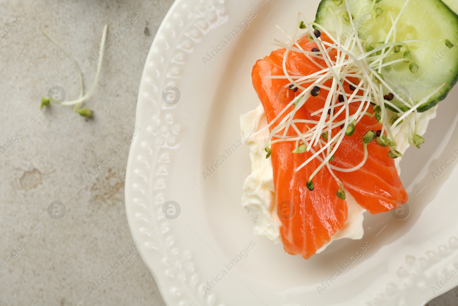 Photo of Delicious bruschetta with salmon, cream cheese and cucumber on light table, closeup. Space for text