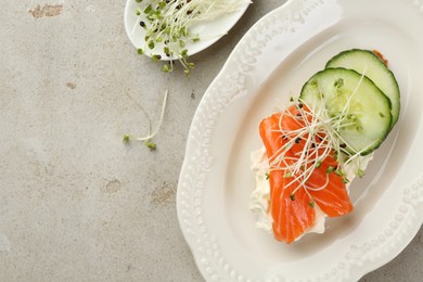 Photo of Delicious bruschetta with salmon, cream cheese and cucumber on light table, top view. Space for text