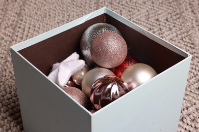 Photo of Different Christmas decor in box on carpet, closeup