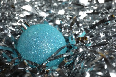 Photo of Beautiful Christmas ball on shiny tinsel, closeup