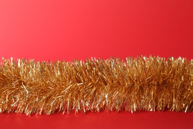 Photo of Beautiful shiny tinsel on red background. Christmas decor