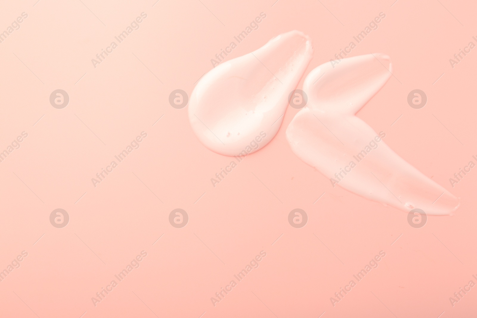 Photo of Cream samples on pink background, top view. Space for text