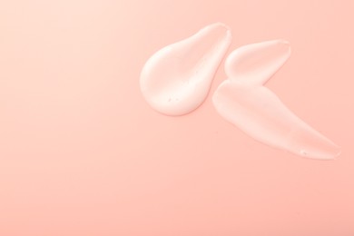 Photo of Cream samples on pink background, top view. Space for text