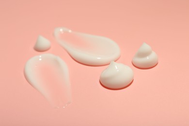 Photo of Cream samples on pink background, closeup. Skincare product