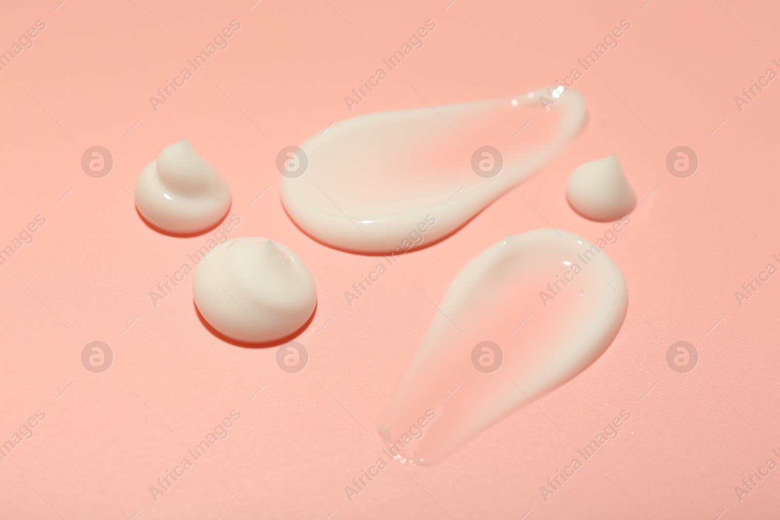 Photo of Cream samples on pink background, closeup. Skincare product