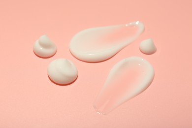 Photo of Cream samples on pink background, closeup. Skincare product