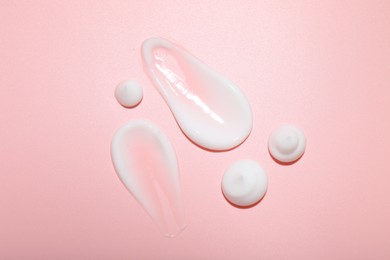 Photo of Cream samples on pink background, top view. Skincare product