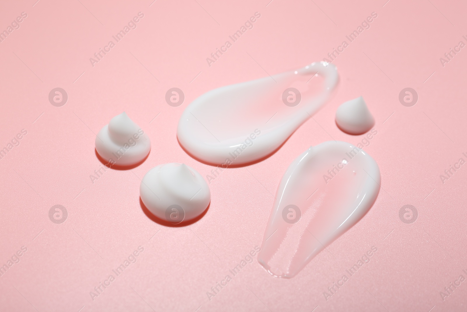 Photo of Cream samples on pink background, closeup. Skincare product