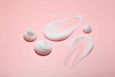 Photo of Cream samples on pink background, closeup. Skincare product