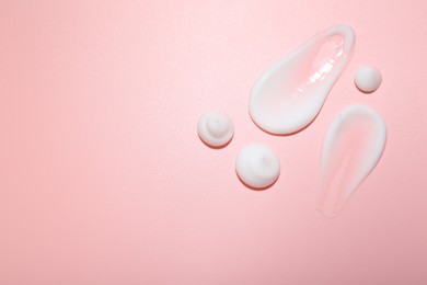 Photo of Cream samples on pink background, top view. Skincare product