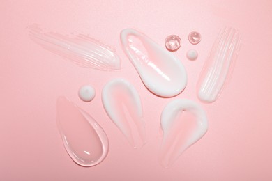 Photo of Cream and gel samples on pink background, top view