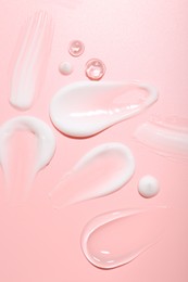 Photo of Cream and gel samples on pink background, top view