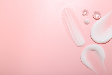 Photo of Cream and gel samples on pink background, top view. Space for text