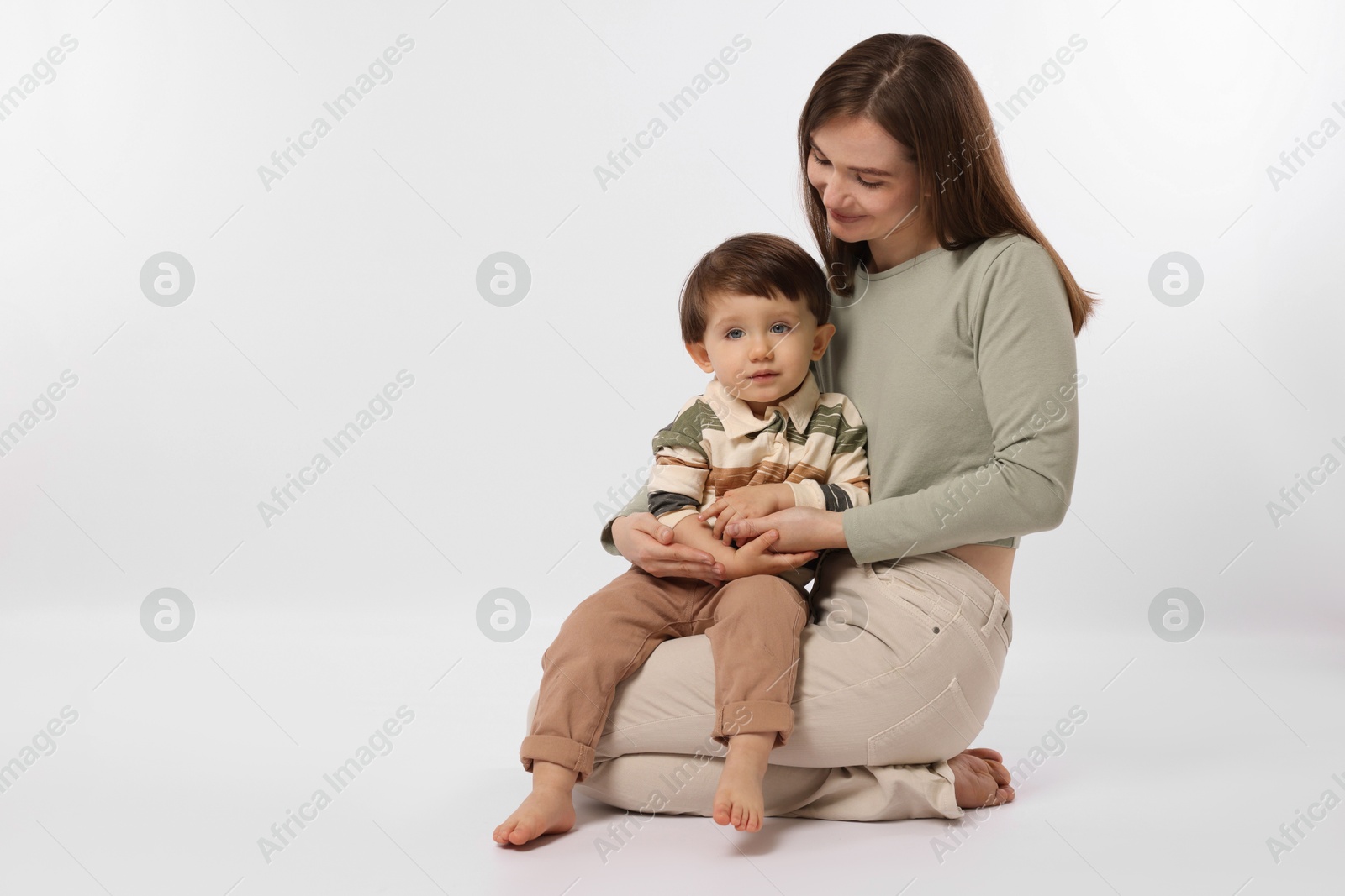 Photo of Happy mother with her cute little son on white background, space for text