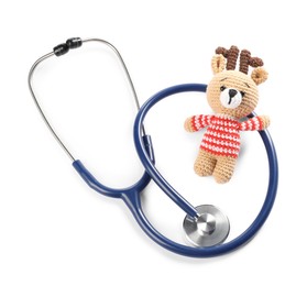 Photo of Pediatrics concept. Toy deer with stethoscope isolated on white, top view