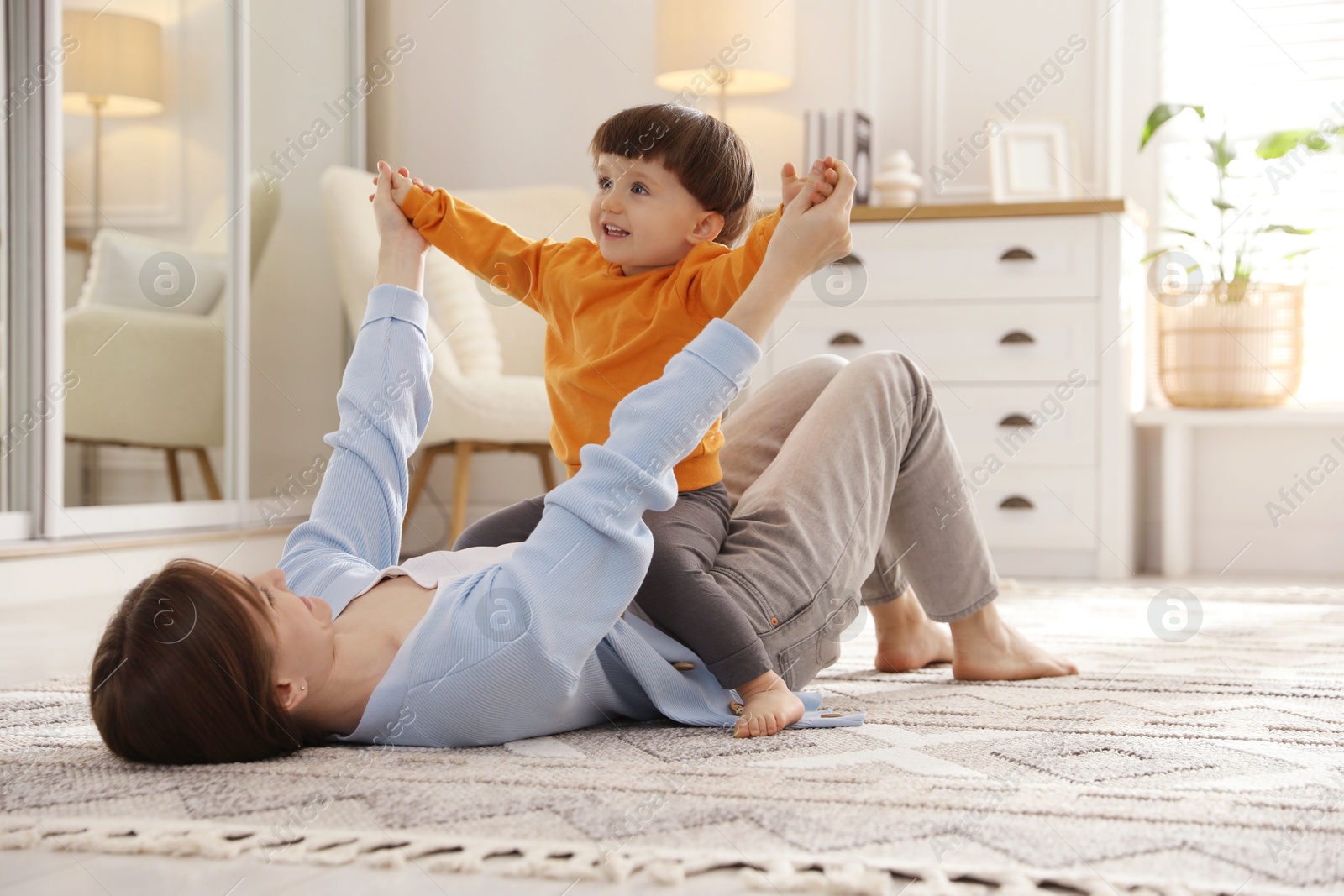 Photo of Mother playing her happy little son at home