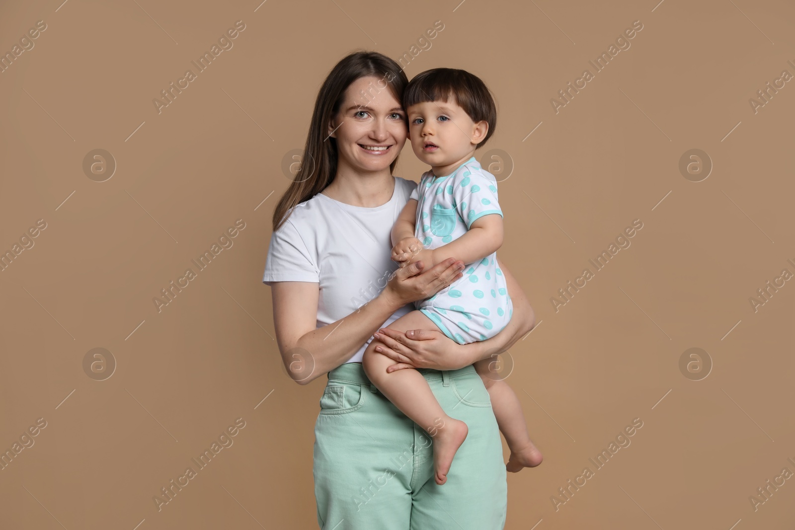 Photo of Family portrait of happy mother with her little son on beige background