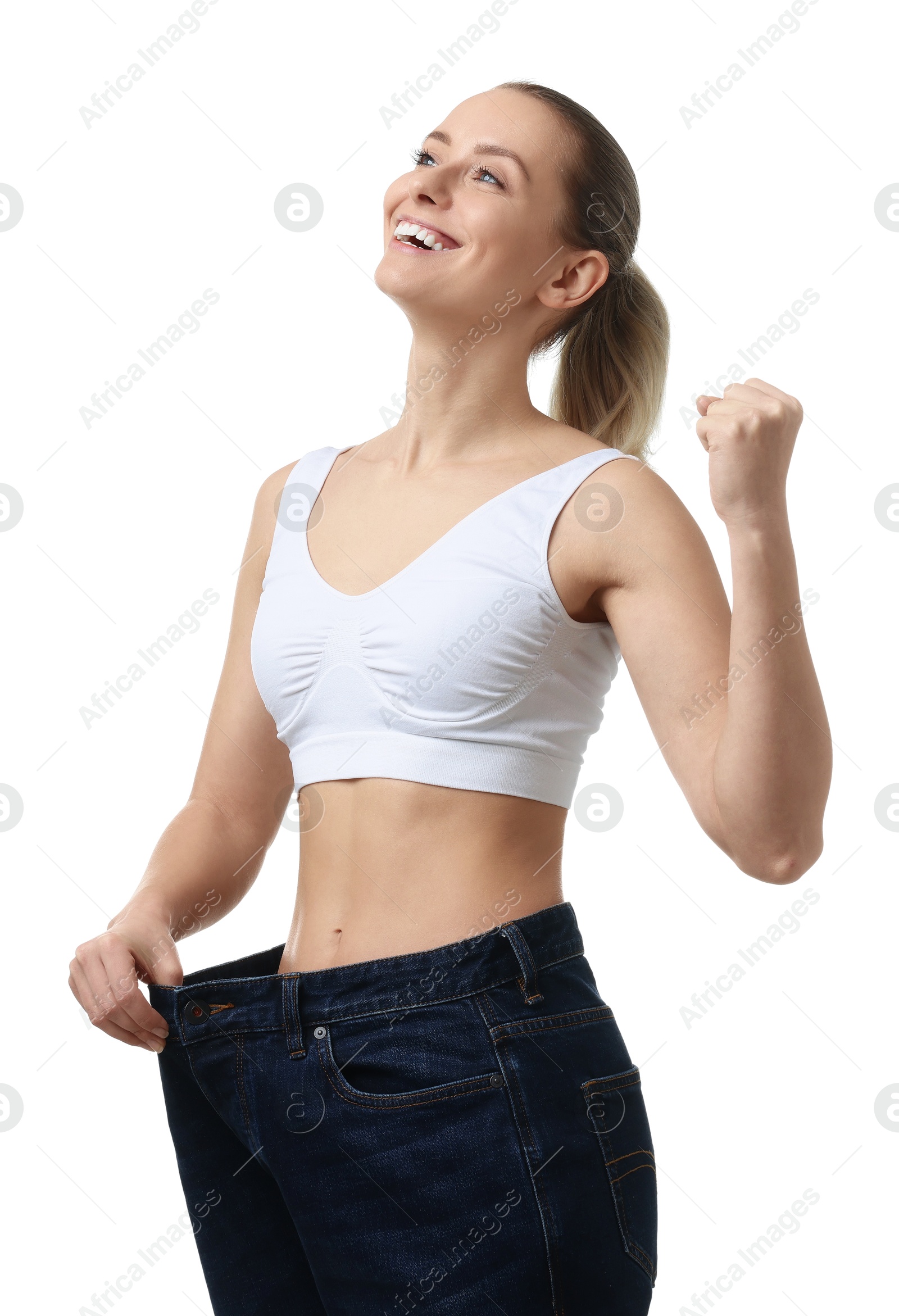 Photo of Weight loss. Happy woman wearing big jeans on white background