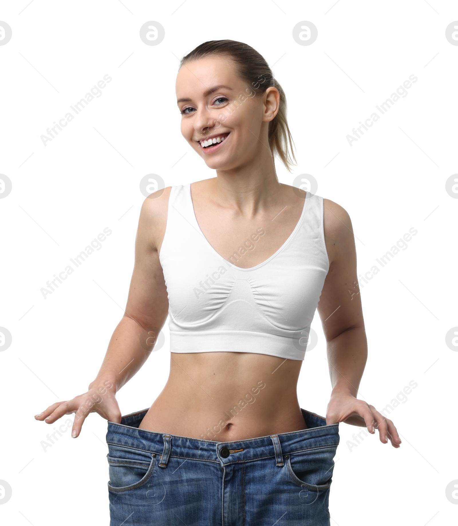 Photo of Weight loss. Happy woman wearing big jeans on white background