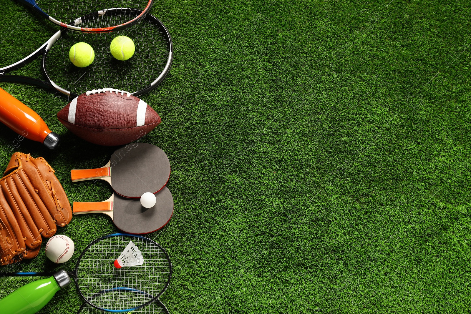 Photo of Different sports equipment on artificial grass, flat lay. Space for text