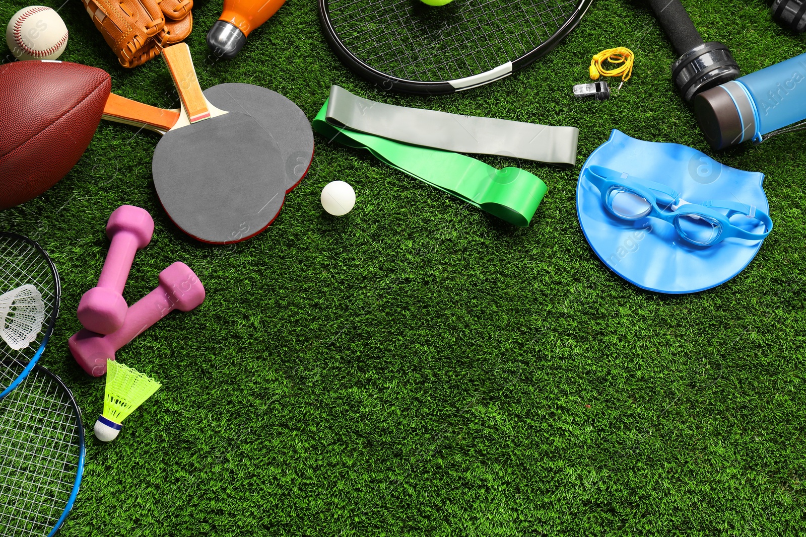 Photo of Different sports equipment on artificial grass, flat lay. Space for text