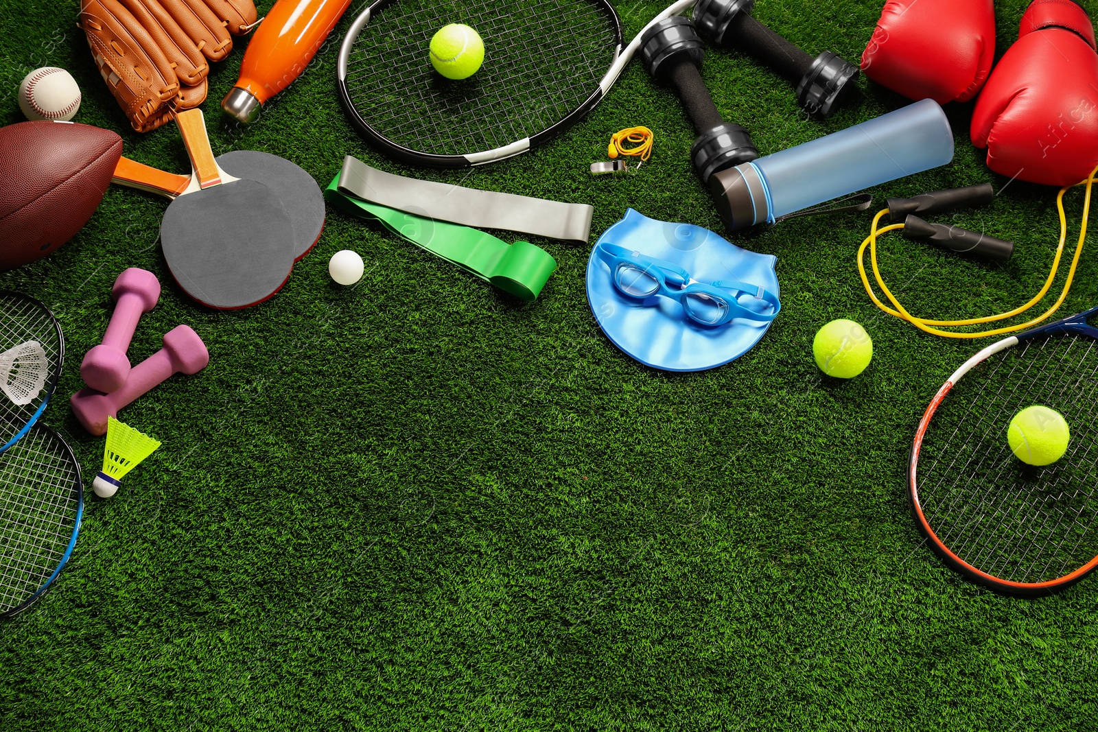 Photo of Different sports equipment on artificial grass, flat lay. Space for text