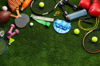 Different sports equipment on artificial grass, flat lay. Space for text