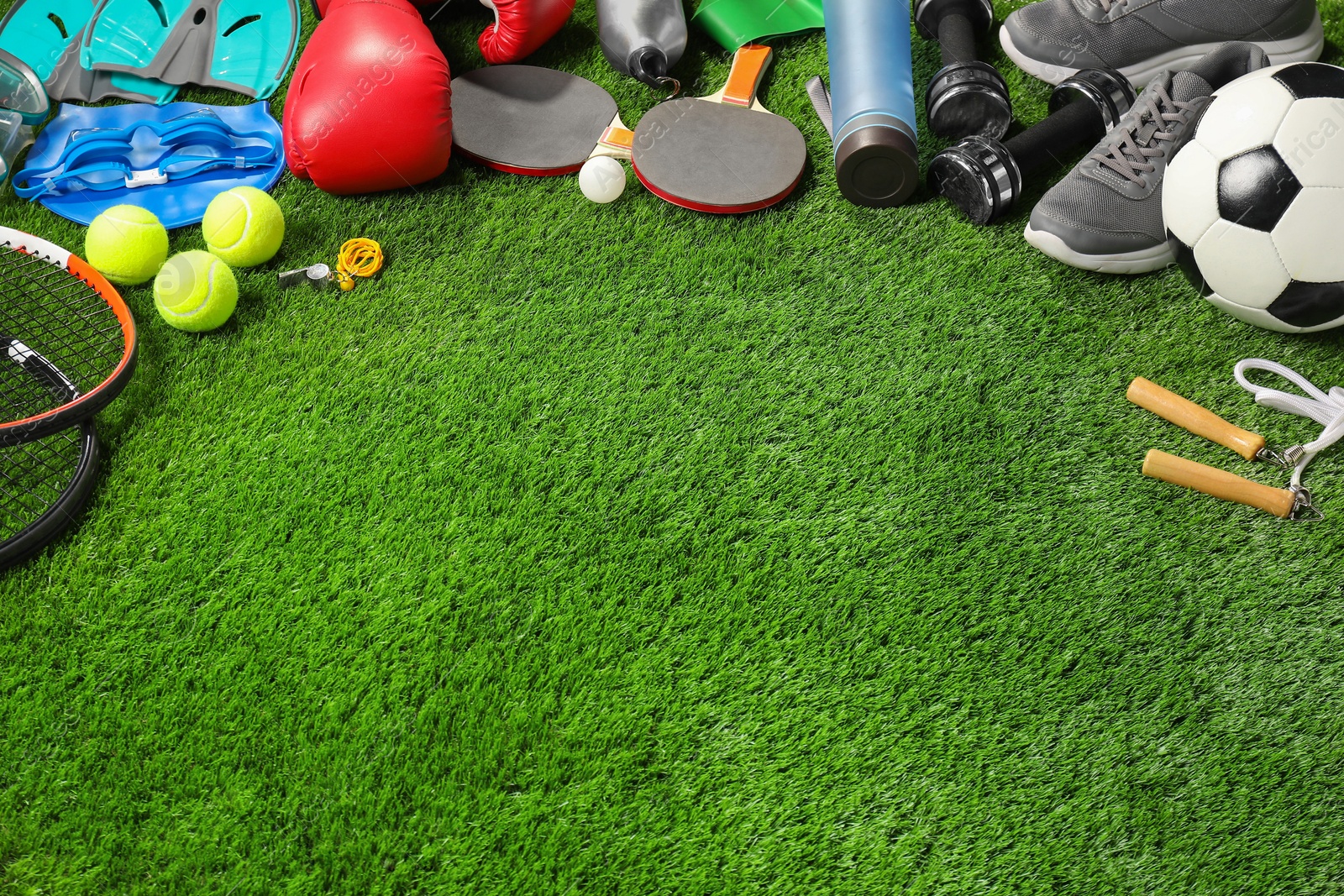 Photo of Different sports equipment on artificial grass, space for text