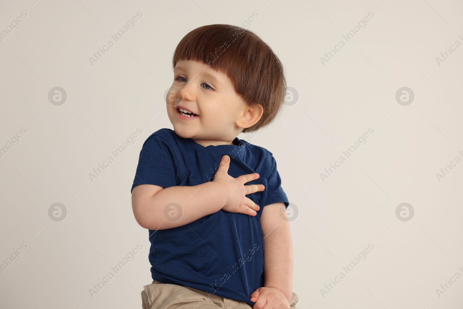 Photo of Portrait of happy little boy on light grey background